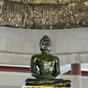 Jade Buddha sculpture with intricate carvings in a serene indoor setting.